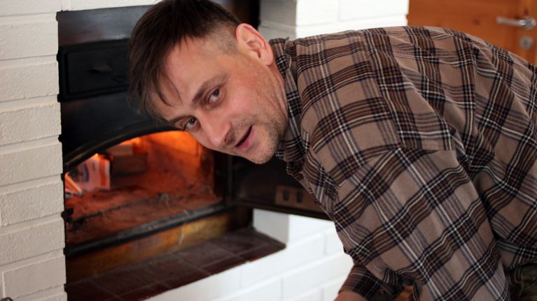 Árpád Kovács sytyttää leivinuunia