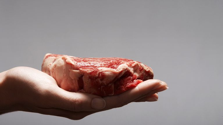 Raaka, kypsentämätön pihvi naisen kämmenellä.