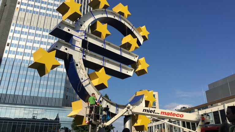 Eurorahan symbolia korjataan Euroopan keskuspankin edessä.