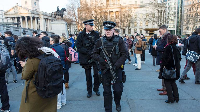 Poliiseja partioimassa kynttilämielenilmauksessa Trafalgarin aukiolla Lontoossa torstaina.