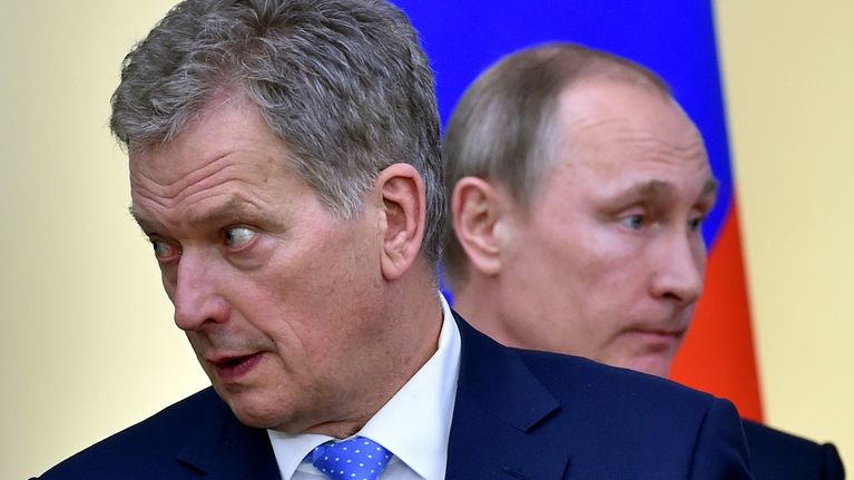 Niinistö katsoo kuvassa vasemmalle ja Putin hänen takanaan oikealle. Taustalla näkyy Venäjän lippu.