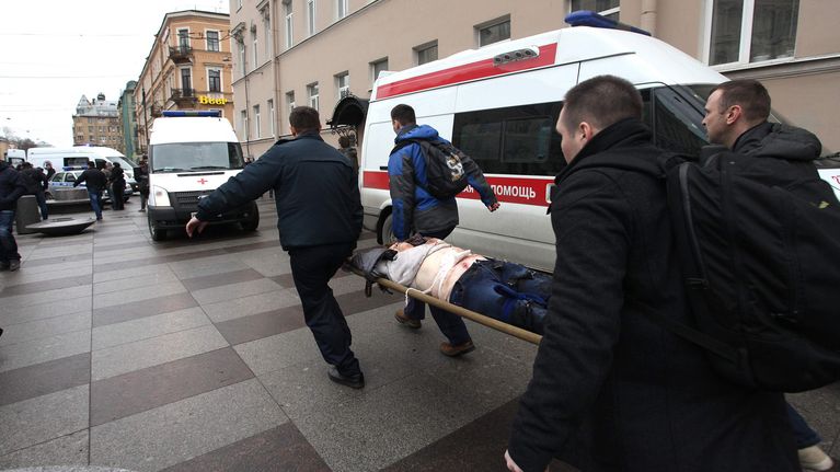 Miestä kannetaan paareilla ambulanssiin Teknologisen instituutin metroaseman ulkopuolella.