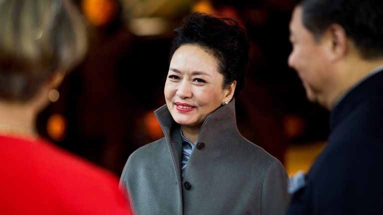 Peng Liyuan hymyilee päällään harmaa villakangastakki. 