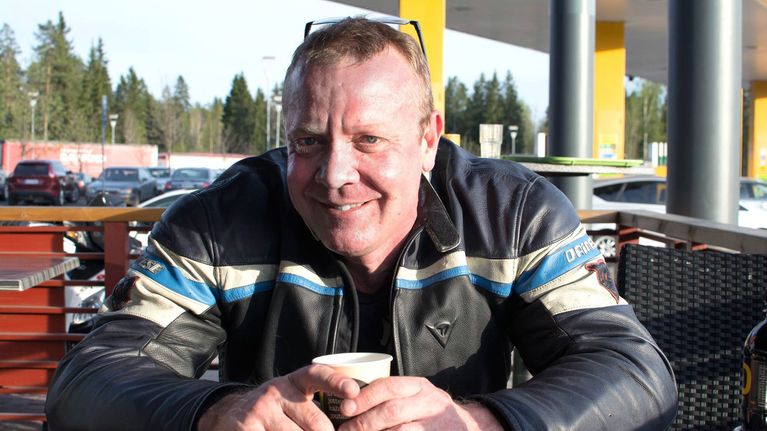 Matti Kannela istuu huolto-asemalla kahvilla