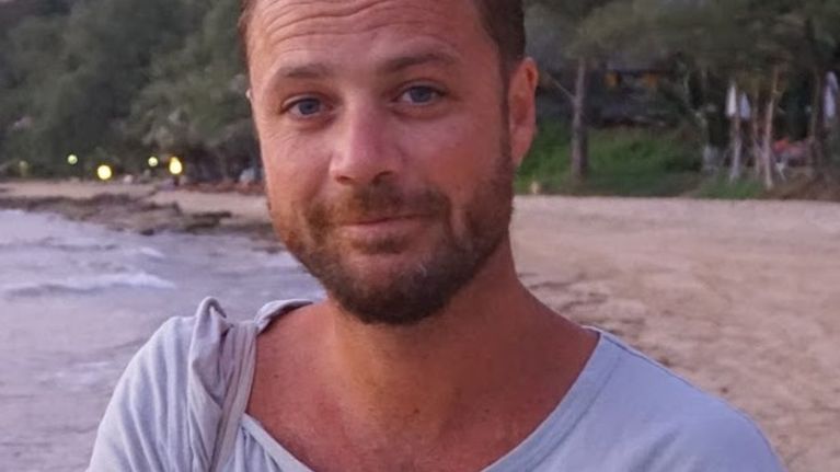 Uhri Chris Bevington katsoo kameraan rannalla.
