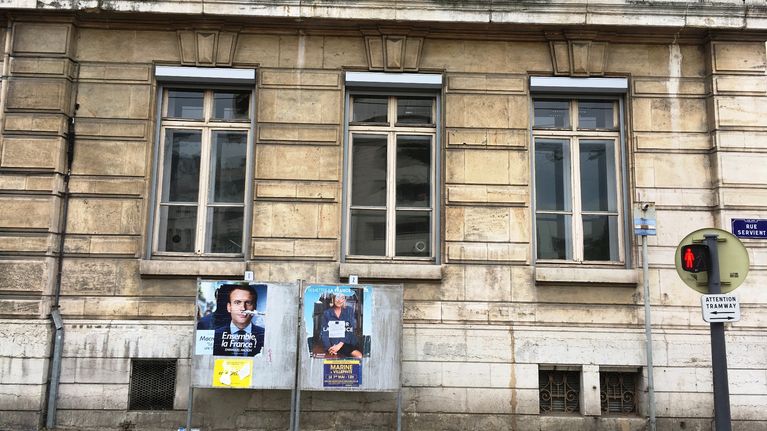 Emmanuel Macronin ja Marine Le Penin vaalimainokset koulun edustalla Lyonissa.