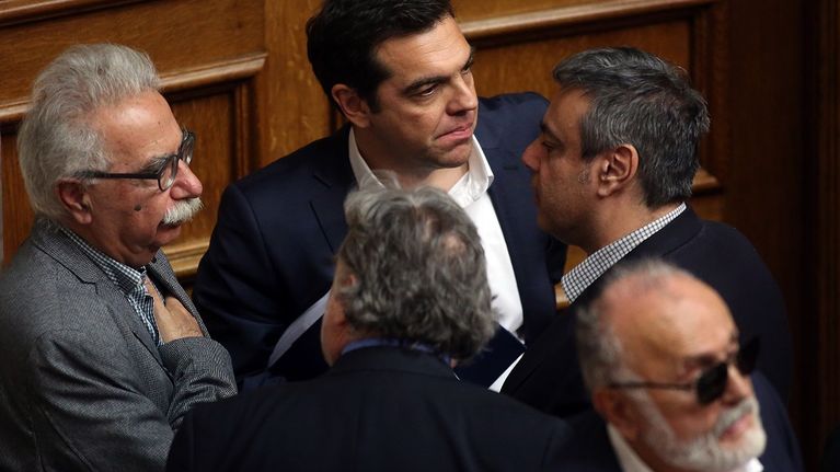 Kreikan pääministeri Alexis Tsipras odottaa äänestystulosta ministereiden keskellä.