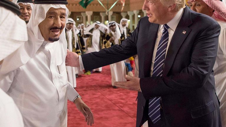 Kuningas Salman ja Donald Trump seisovat vierekkäin. Trump koskettaa kuninkaan olkapäätä.