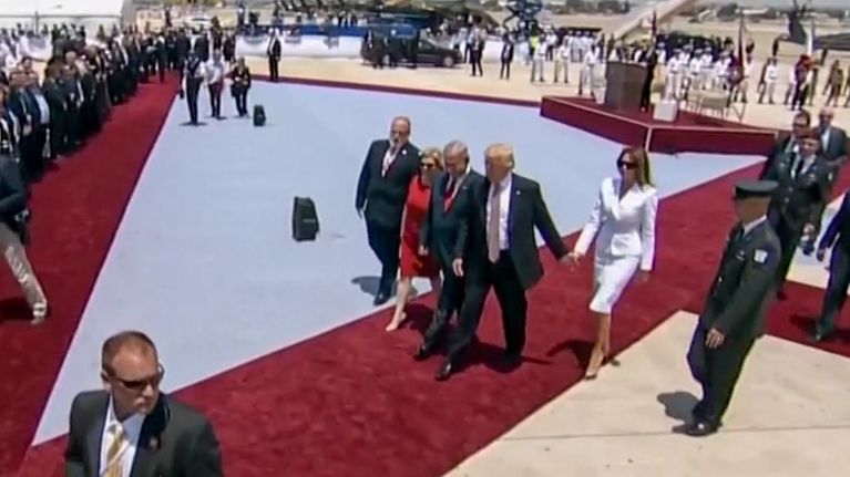 presidenttipari kävellee punaisella matolla