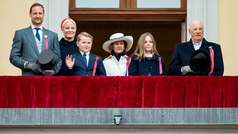 Norjan kuninkaalliset punaisen sametin peittämällä parvekkeella. 