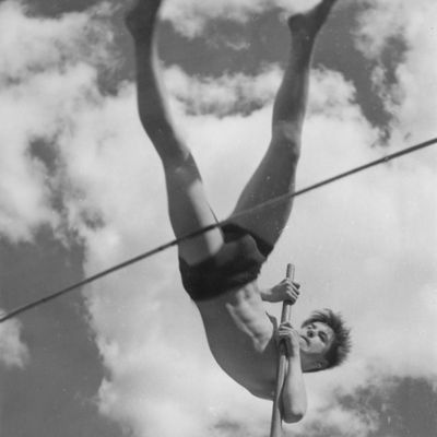 Nuori mies, Jussi Huttunen, hyppää seivästä 1950-luvulla.